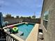 In-ground pool with inflatables, poolside seating, and lush desert landscaping at 9825 W Trumbull Rd, Tolleson, AZ 85353