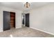 Bright bedroom features carpeted floors, an open closet with wood interior, and dark doors and trim at 1010 W 5Th Pl, Mesa, AZ 85201