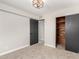Bright bedroom features carpeted floors, an open closet with wood interior, and dark doors and trim at 1010 W 5Th Pl, Mesa, AZ 85201