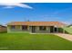 Charming single-story home boasts green paint, yellow trim, large front lawn and a covered parking area at 1010 W 5Th Pl, Mesa, AZ 85201