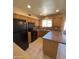 Cozy kitchen featuring black appliances, tile backsplash, and wooden cabinets for ample storage at 1018 W Helena Dr, Phoenix, AZ 85023