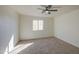 Bright bedroom with neutral carpet, ceiling fan, and a window bringing in natural light at 11629 W Washington St, Avondale, AZ 85323
