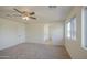 Bedroom with neutral carpet and a window as well as access to the ensuite bathroom at 11629 W Washington St, Avondale, AZ 85323