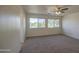 Large bedroom with neutral carpet and two large windows with a view of the mature trees outside at 11629 W Washington St, Avondale, AZ 85323