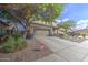 Charming home featuring a spacious driveway and attached two-car garage, accented by a mature shade tree and desert landscaping at 11629 W Washington St, Avondale, AZ 85323