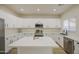 Modern white kitchen with stainless appliances, quartz countertops, and a central island work space at 11629 W Washington St, Avondale, AZ 85323
