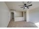 Spacious living room with neutral carpet, ceiling fan and arched doorways to other areas at 11629 W Washington St, Avondale, AZ 85323