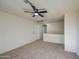 Neutral carpet and ceiling fan in a light-filled living room featuring easy access to other rooms at 11629 W Washington St, Avondale, AZ 85323