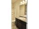 Updated bathroom with a granite countertop, dark cabinets, white toilet, and shower combo, ready for relaxation at 1246 E Thomas Dr, Casa Grande, AZ 85122