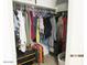 Walk-in closet featuring organized hanging clothes, a luggage, and a storage container at 1246 E Thomas Dr, Casa Grande, AZ 85122
