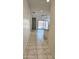 Bright hallway with tile flooring leading to a sliding glass door and open floor plan at 1246 E Thomas Dr, Casa Grande, AZ 85122