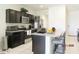 Well-lit kitchen features dark cabinets, stainless steel appliances, and a breakfast bar with seating at 1246 E Thomas Dr, Casa Grande, AZ 85122