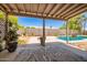 Covered patio overlooks the pool, landscaping and block fence at 12529 N 83Rd Ln, Peoria, AZ 85381
