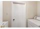 Laundry room with a white door and appliances at 12529 N 83Rd Ln, Peoria, AZ 85381