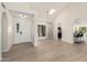 Bright living room with a skylight, arched doorways, wood-look floors, and a glimpse into an eat-in kitchen at 12529 N 83Rd Ln, Peoria, AZ 85381