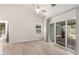 Spacious living room featuring a ceiling fan, wood-look flooring, and sliding glass doors to the backyard at 12529 N 83Rd Ln, Peoria, AZ 85381