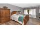 Bright bedroom features a wooden bed frame, armoire, and a cozy sitting area by the window at 1298 E Buffalo St, Chandler, AZ 85225