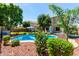 A beautiful backyard with a pool, lounge chairs, mature landscaping and a patio set at 13005 W Vista Paseo Dr, Litchfield Park, AZ 85340