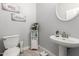 Cozy half bathroom with a pedestal sink, decorative signs, and neutral paint at 13005 W Vista Paseo Dr, Litchfield Park, AZ 85340