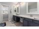 Well-lit bathroom featuring gray vanity, light countertop, and two mirrors at 13005 W Vista Paseo Dr, Litchfield Park, AZ 85340