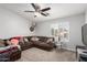 A comfortable living room is furnished with a large sectional sofa, pillows, and shutters on the windows at 13005 W Vista Paseo Dr, Litchfield Park, AZ 85340