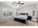 Bedroom with ceiling fan, plantation shutters, dark wood furniture, and tan carpet at 13005 W Vista Paseo Dr, Litchfield Park, AZ 85340