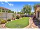 Spacious backyard features artificial turf, desert landscaping, brick borders, and a patio for outdoor entertaining and relaxing at 1314 S Bridgegate Dr, Gilbert, AZ 85296
