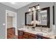 Elegant bathroom featuring a double vanity with granite countertops, dark wood cabinets, and stylish mirrors at 1314 S Bridgegate Dr, Gilbert, AZ 85296