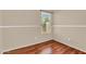 Bedroom with light tan walls, white trim, a window with blinds and wood-look floors at 1314 S Bridgegate Dr, Gilbert, AZ 85296