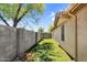 Narrow side yard is covered with artificial turf for easy maintenance; a block wall runs the length of the property at 1314 S Bridgegate Dr, Gilbert, AZ 85296