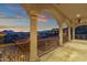 Expansive covered patio with stone columns, iron railing, and stunning city views at dusk at 15536 E Heavenly Vista Trl, Fountain Hills, AZ 85268