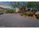 Expansive brick driveway leading to a desert home with lush landscaping and mature trees at 15536 E Heavenly Vista Trl, Fountain Hills, AZ 85268