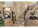 A grand foyer boasts tile floors, decorative lighting, and a beautiful staircase with ironwork and tile accents at 15536 E Heavenly Vista Trl, Fountain Hills, AZ 85268