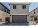 Charming two-story home with a gray garage door, desert landscaping, and a walkway gate at 15593 S 180Th Ln, Goodyear, AZ 85338