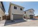 Charming two-story home with a gray garage door, desert landscaping, and a walkway gate at 15593 S 180Th Ln, Goodyear, AZ 85338