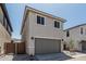 Charming two-story home with a gray garage door, desert landscaping, and a walkway gate at 15593 S 180Th Ln, Goodyear, AZ 85338