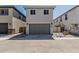 Charming two-story home with a gray garage door, desert landscaping, and a walkway gate at 15593 S 180Th Ln, Goodyear, AZ 85338