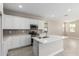 Bright kitchen features stainless steel appliances, white cabinets, and a center island at 15593 S 180Th Ln, Goodyear, AZ 85338