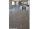 Bright living room with tile flooring flowing into an open kitchen featuring an island and modern appliances at 15593 S 180Th Ln, Goodyear, AZ 85338