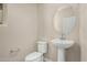 Small powder room with neutral paint, pedestal sink, oval mirror, and toilet at 15593 S 180Th Ln, Goodyear, AZ 85338