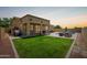 Expansive backyard with a covered patio, lush green lawn, and ample space for outdoor activities at 157 N 110Th Ave, Avondale, AZ 85323