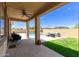 Inviting covered patio extends to backyard with grass area, furniture, and refreshing pool at 157 N 110Th Ave, Avondale, AZ 85323