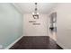 The dining room has dark laminate flooring, a decorative light fixture, and an archway leading to another room at 157 N 110Th Ave, Avondale, AZ 85323