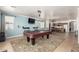 Entertainment haven featuring a pool table and TV, complemented by a cozy bar area and seamless kitchen access at 157 N 110Th Ave, Avondale, AZ 85323