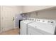 Functional laundry room featuring a washer, dryer, sink, and door to the exterior at 157 N 110Th Ave, Avondale, AZ 85323