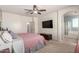 Spacious main bedroom features a ceiling fan, TV, and an archway leading to the primary bathroom at 157 N 110Th Ave, Avondale, AZ 85323