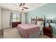 The spacious main bedroom has a ceiling fan, a window with patterned drapes, and a comfortable bed at 157 N 110Th Ave, Avondale, AZ 85323