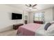 A main bedroom features a ceiling fan, TV, and a window with patterned drapes at 157 N 110Th Ave, Avondale, AZ 85323