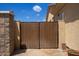 Wooden gate leading to a landscaped side yard, enclosed by a stucco wall and providing privacy at 157 N 110Th Ave, Avondale, AZ 85323