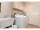 Functional laundry room includes washer, dryer, storage cabinets, and a utility sink at 16066 W Sandia Park Dr, Surprise, AZ 85374